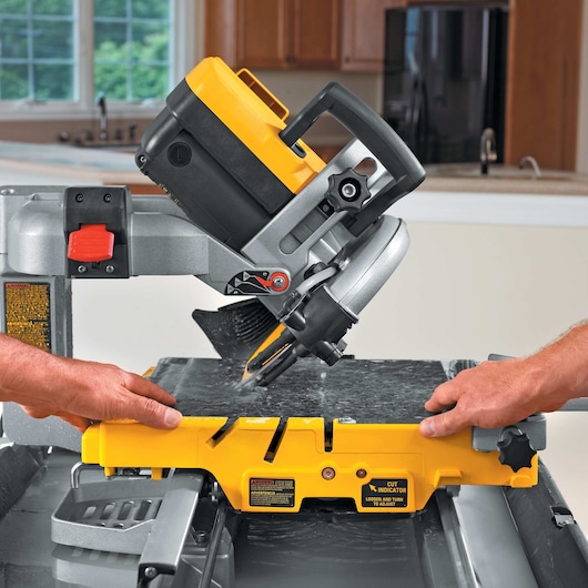 wet tile saw being used by two persons