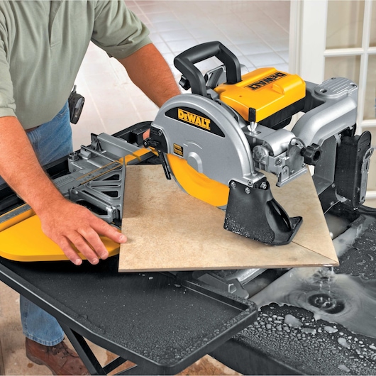 wet tile saw being used by person to cut tile diagonally
