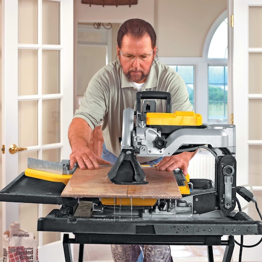 wet tile saw being used by person to cut tile
