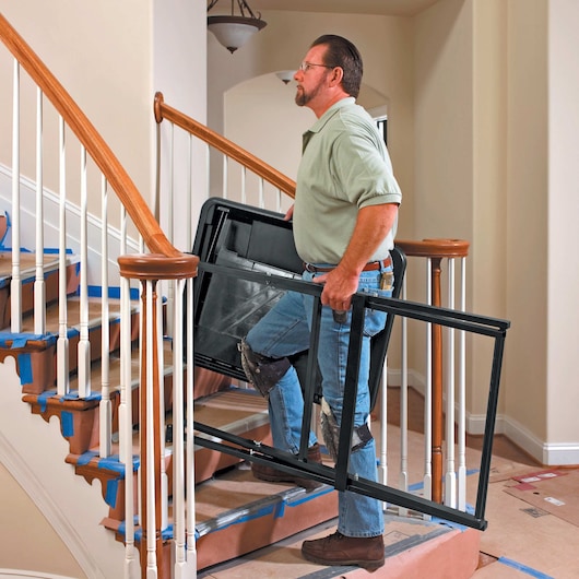 wet tile saw base being carried by person on stairs