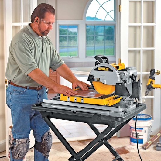wet tile saw being used by person to cut tile