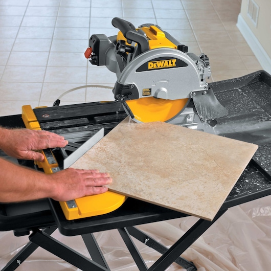 wet tile saw being used by person to cut tile