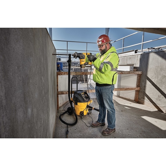 Profile of SDS Plus rotary hammer with dust extractor being used by person