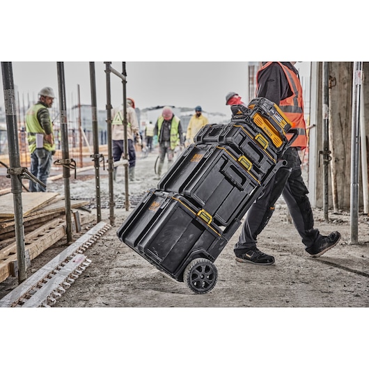 Powershift Charger DCBPSC0551 and Battery DCBPS0554 connected to ToughSystem storage being wheeled across a construction site