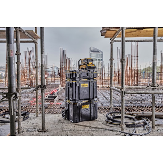 Powershift Charger DCBPSC0551 and Battery DCBPS0554 stacked on top of ToughSystem storage