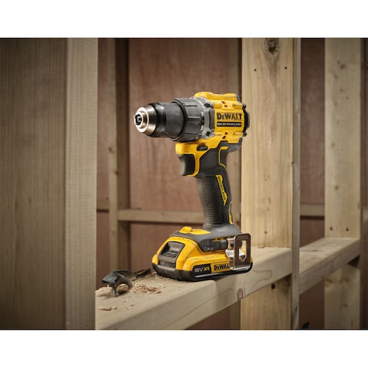 18V XR Brushless Compact Hammer Drill Driver with 18V 2Ah battery 3/4 view sitting on wooden frame