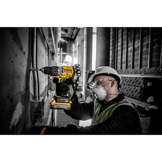 18V XR hammer drill driver with a compact Powerstack battery drilling a hole for a clip fastening
