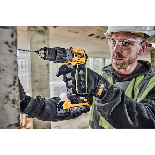 Construction worker drills into a wall using a DCD805NT 18V XR Brushless Hammer Drill
