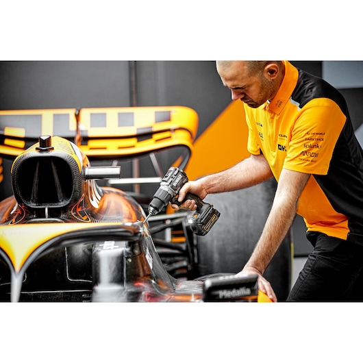 McLaren pit crew member using Limited Editon DEWALT/McLaren Drill Driver on McLaren F1 car