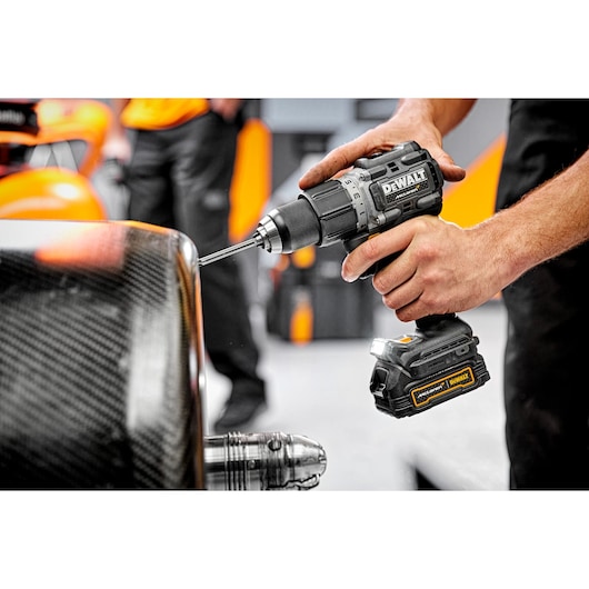 Close view of McLaren pit crew member using Limited Editon DEWALT/McLaren Drill Driver on McLaren carbon fibre wheel  