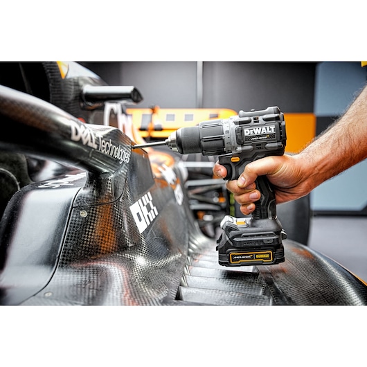 Close view of Limited Editon DEWALT/McLaren Drill Driver being used in McLaren garage on car chassis