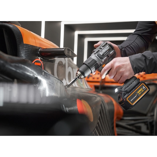 McLaren mechanic using DEWALT/McLaren drill driver on McLaren racing car