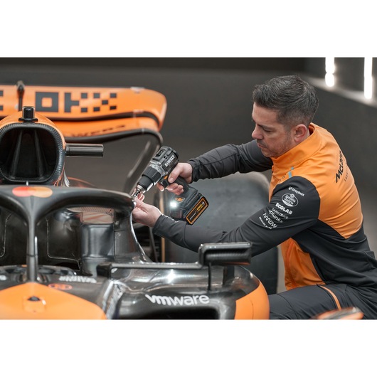 McLaren mechanic using DEWALT/McLaren drill driver on McLaren racing car