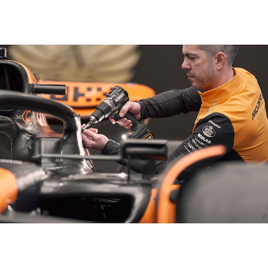 McLaren mechanic using DEWALT/McLaren drill driver on McLaren racing car
