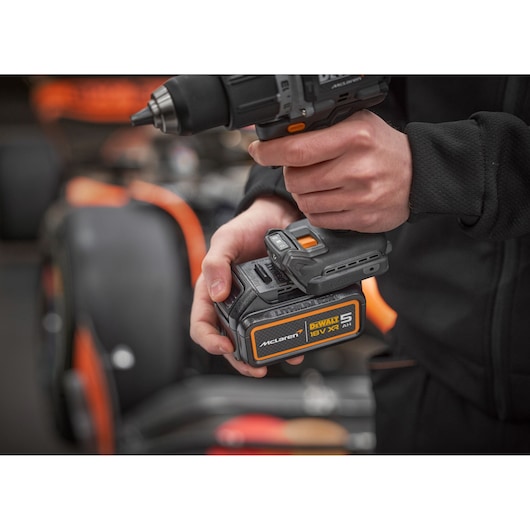 Battery being connected to a DEWALT/McLaren drill driver