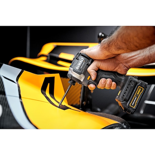 Limited Editon DEWALT/McLaren Impact Driver being used at an angle on car chassis