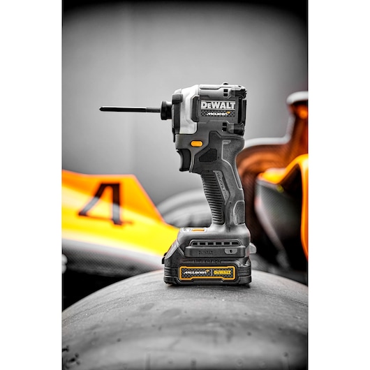 Portrait shot of Limited Editon DEWALT/McLaren Impact Driver sitting on top of F1 car tyre