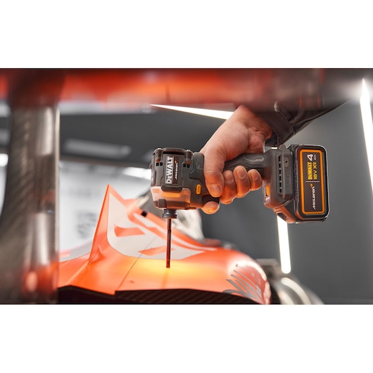 Close view of DEWALT/McLaren impact driver being used on McLaren racing car