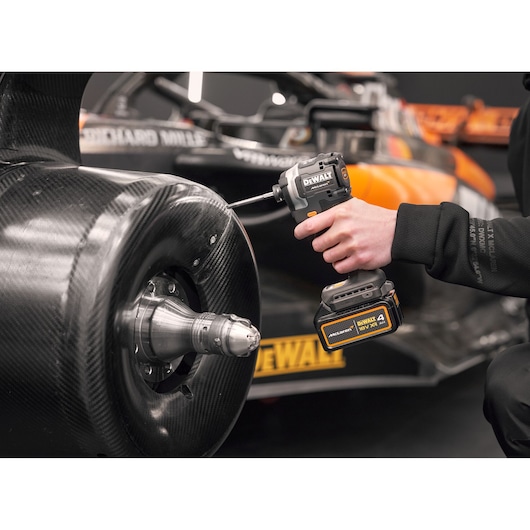Close view of DEWALT/McLaren impact driver being used on McLaren racing car