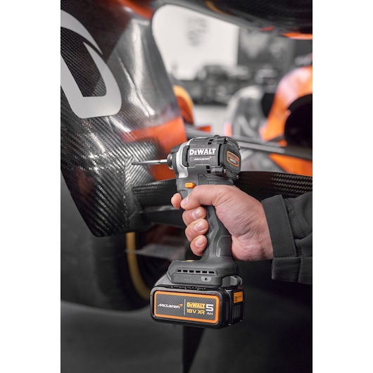 Close view of DEWALT/McLaren impact driver being used on McLaren racing car