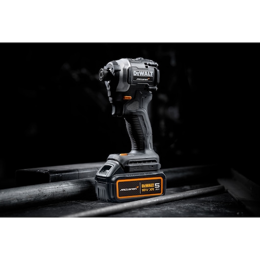 DEWALT/McLaren Impact Driver with 18V XR 5Ah battery 3/4 view in staged dark setting