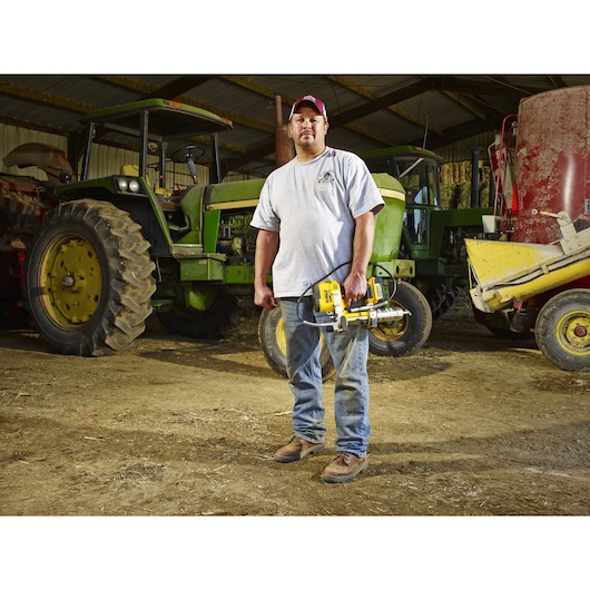 Grease gun being held by person