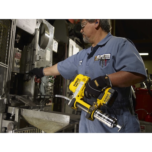 Grease gun being used by a person