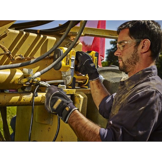 Grease gun being used by a person outdoors