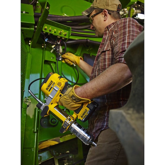 Grease gun being used by a person