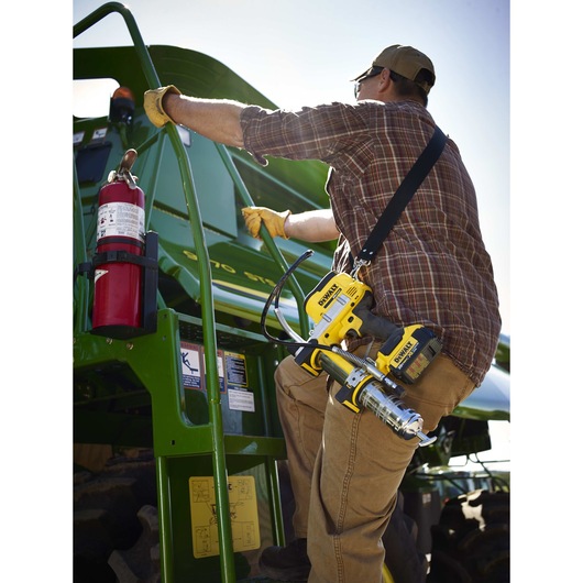 Grease gun being carried by person outdoors