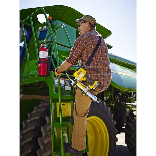Grease gun being carried by person outdoors