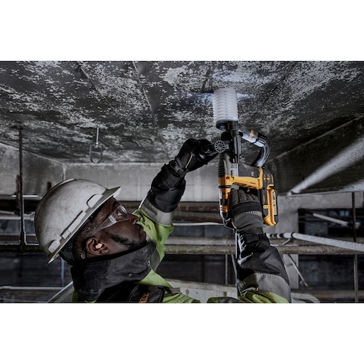 Atomic 20 volt five eighths inch brushless cordless SDS plus rotary hammer kit being used by a person.