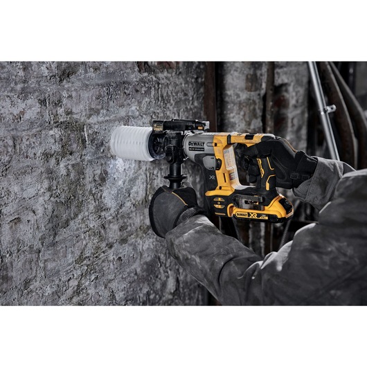 Atomic 20 volt five eighths inch brushless cordless SDS plus rotary hammer kit being used to hammer wall.