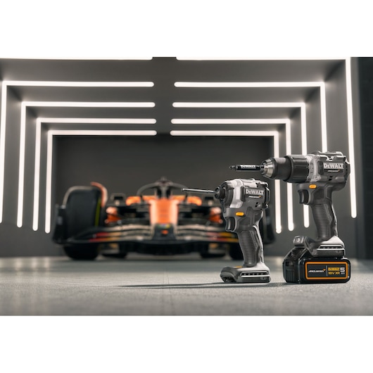 DEWALT/McLaren drill driver and impact driver stands in the foreground with a McLaren racing car in the background