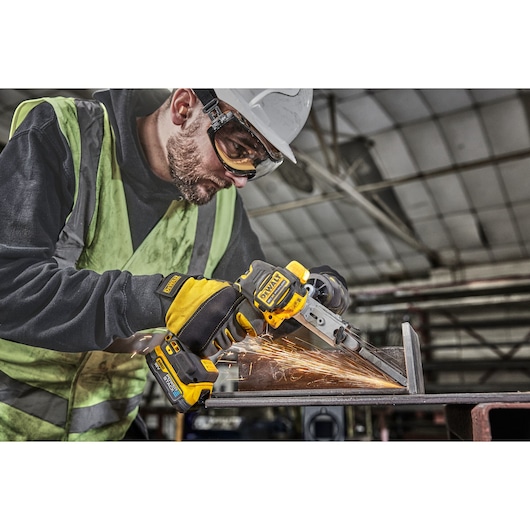 Worker in high vis  using 18V XR Band File to sand metal