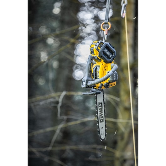 The 54V top handle chainsaw suspended in mid-air attached to harness