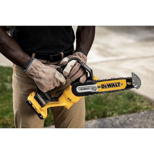 Worker holding an 18V XR Brushless Chain Saw