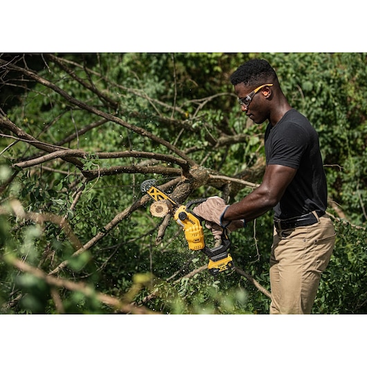 18V XR Brushless Chain Saw cutting a thick tree branch