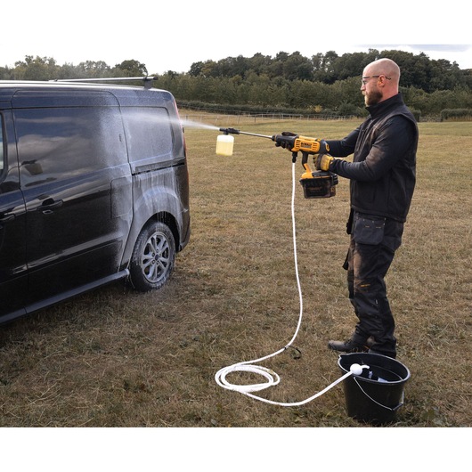 Man using the DEWALT 54V XR FLEXVOLT Power Cleaner to clean the back of a van