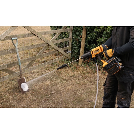 DEWALT 54V XR FLEXVOLT Power Cleaner cleaning mud from a spade