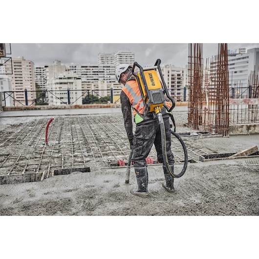 Construction working concrete pouring using Powershift Backpack Concrete Vibrator and hose