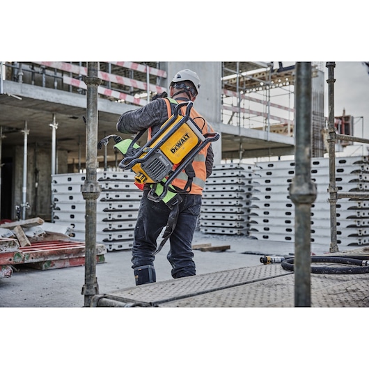 Worker places the Powershift Backpack Concrete Vibrator onto his shoulder
