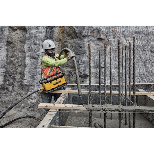Construction worker preparing to pour concrete using Powershift Powerpack Concrete Vibrator and hose
