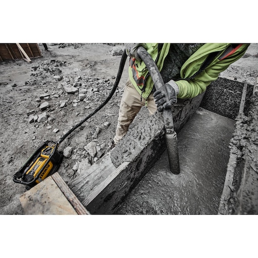 Construction worker using Powershift Powerpack Concrete Vibrator and hose