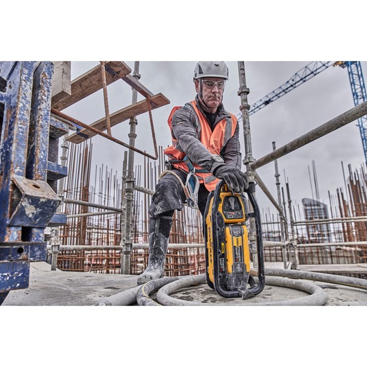 Construction worker preparing to use Powershift Powerpack Concrete Vibrator and hose