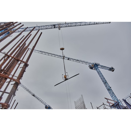 A crane on a construction site lifts a Powershift Screed 