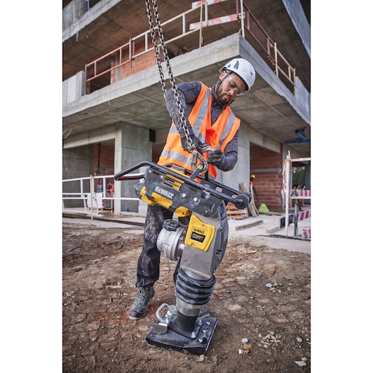 Construction worker connecting a Powershift Rammer to a crane hook