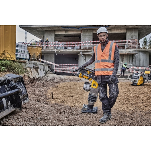 Worker standing against Powershift Rammer on a construction site