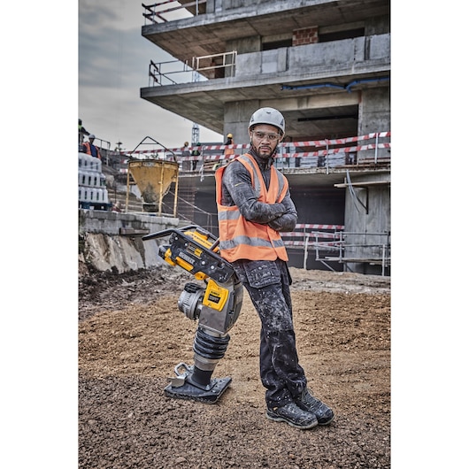 Worker leaning against Powershift Rammer on a construction site