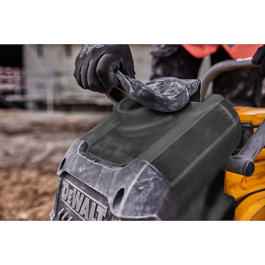 Worker removes rubber water tank cap on a Powershift Plate Compactor